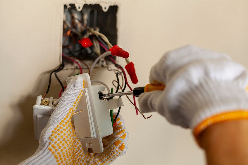 An electrician is replacing residential electrical switches.